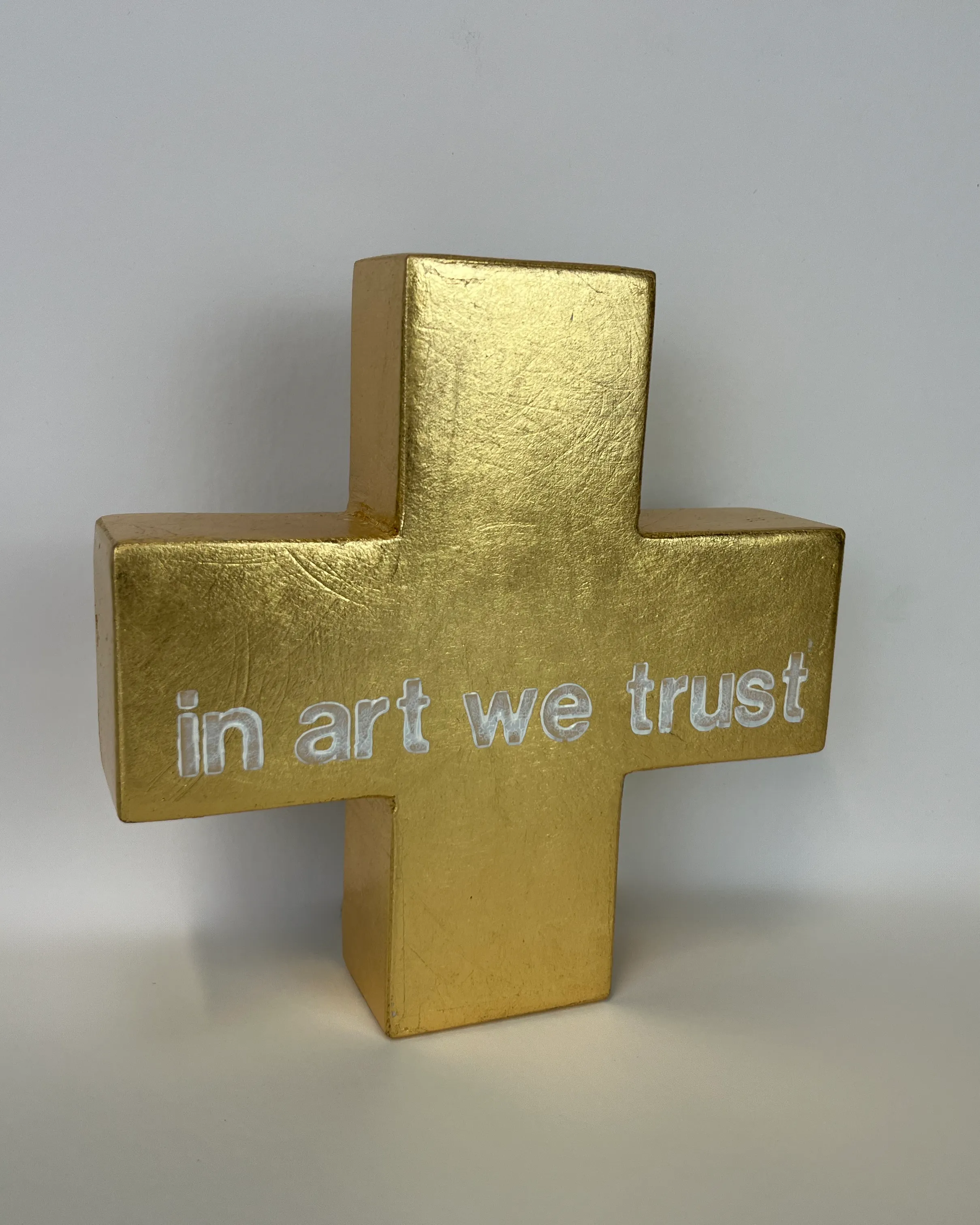 Goldenes Kreuz, 3D Kunstobjekt mit Aufschrift "In Art We Trust"